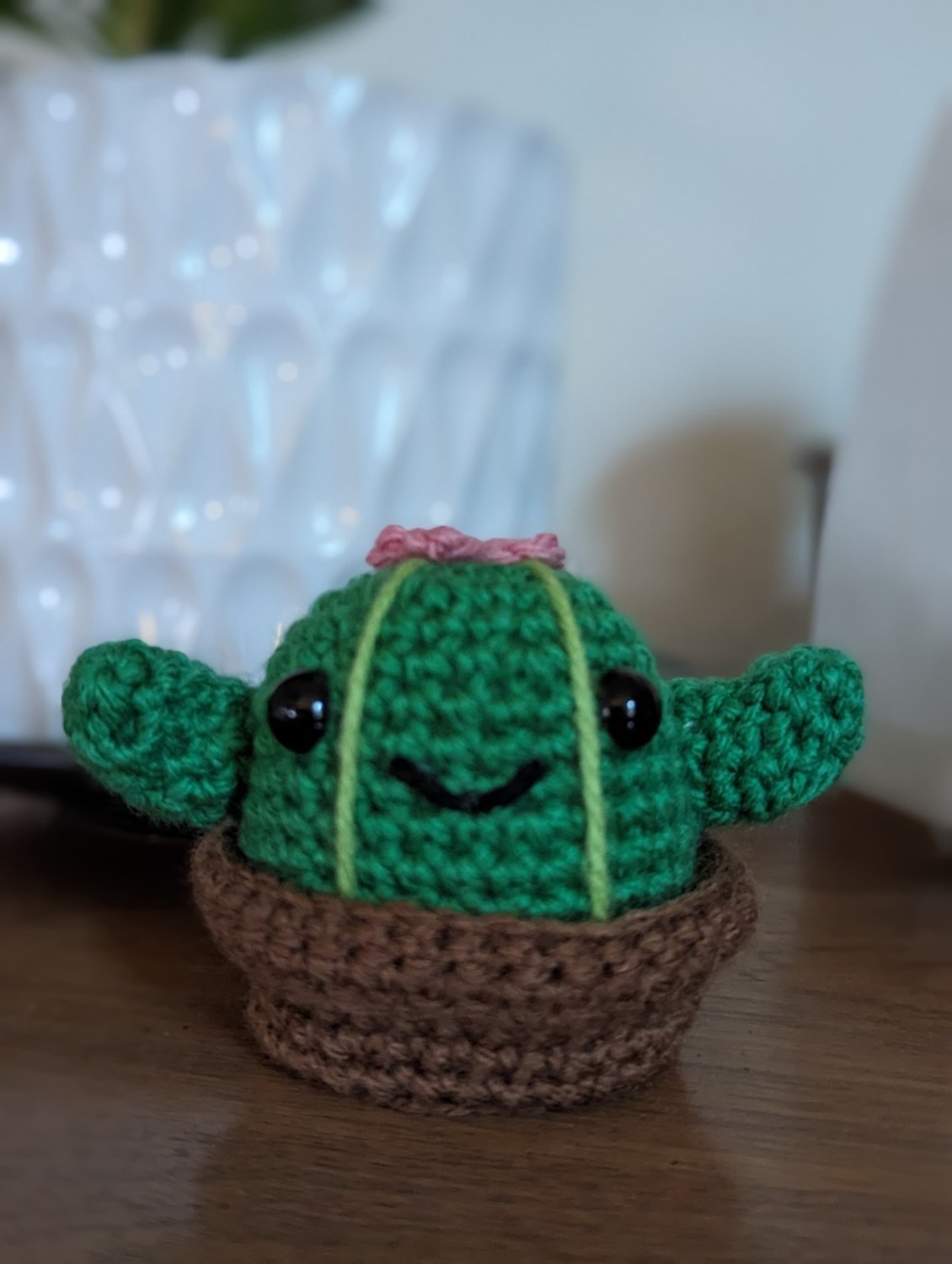 Clint the Cactus, a smiling green crochet cactus with a pink flower in a brown pot